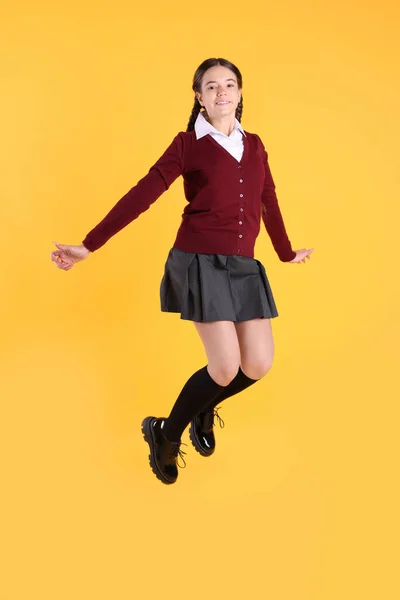 Adolescente Uniforme Escolar Saltando Sobre Fondo Amarillo —  Fotos de Stock