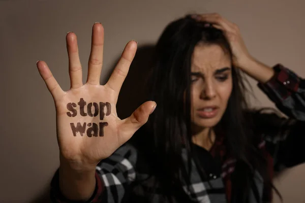 Zdenerwowana Młoda Kobieta Pokazuje Dłoń Zwrotem Stop War Pobliżu Beżowej — Zdjęcie stockowe