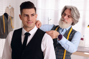 Atölyede müşteriyle çalışan profesyonel terzi