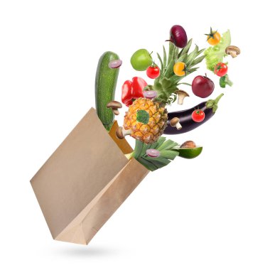 Beyaz arka planda farklı meyve ve sebzelerle dolu kese kağıdı.
