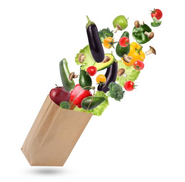 Beyaz arka planda farklı meyve ve sebzelerle dolu kese kağıdı.