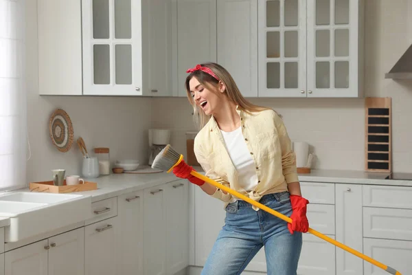 Vrouw Met Bezem Zingen Tijdens Het Schoonmaken Keuken — Stockfoto