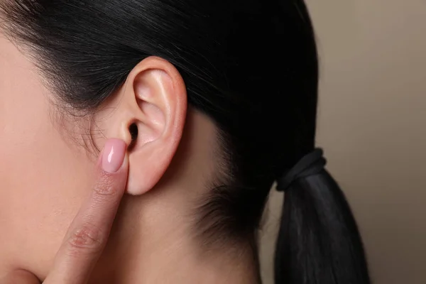 Žena Ukazuje Své Ucho Šedém Pozadí Detailní Záběr — Stock fotografie
