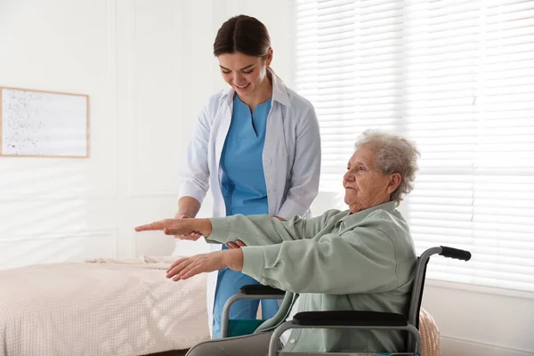 Oudere Vrouw Een Rolstoel Doet Lichamelijke Oefening Binnen Gezondheidszorg Thuis — Stockfoto