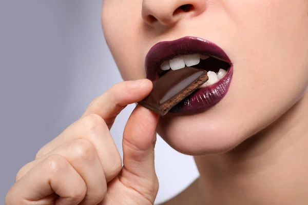 Young Woman Beautiful Lips Makeup Eating Chocolate Light Background Closeup — Foto de Stock