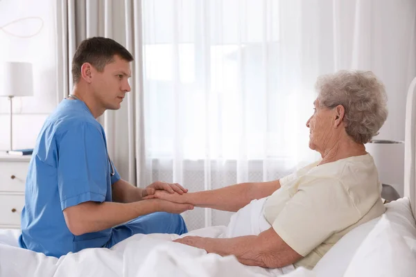 介護者は寝室で先輩女性と話をする 在宅医療サービス — ストック写真