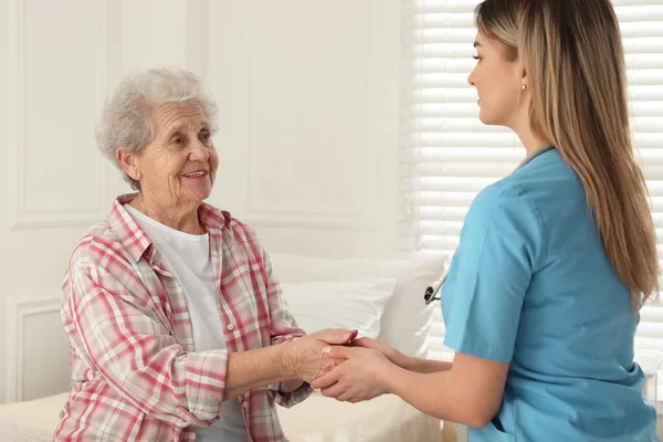 Νεαρός Φροντιστής Μιλάει Ηλικιωμένη Γυναίκα Στο Δωμάτιο Αρχική Υπηρεσία Υγειονομικής — Φωτογραφία Αρχείου