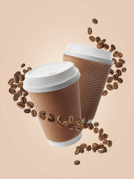 Coffee to go. Paper cups and roasted beans flying on beige background