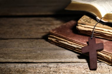Tahta Hıristiyan haçı ve eski kitaplar, yakın plan. Metin için boşluk
