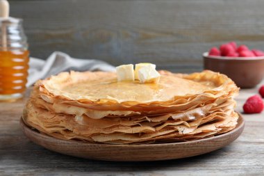 Ahşap masada erimiş tereyağlı bir yığın lezzetli krep.