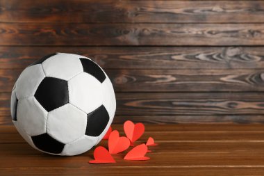 Futbol topu ve kalpler tahta masada. Metin için boşluk