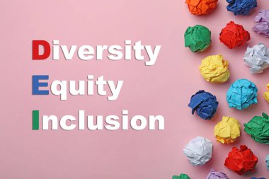 Kısaltma DEI - Çeşitlilik, Equity, Inclusion ve pembe arka planda renkli kağıt toplar, düz uzanma