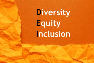 Kısaltma DEI - Çeşitlilik, Eşitlik, Katılım ve turuncu arkaplan üzerine buruşuk kağıt, üst görünüm