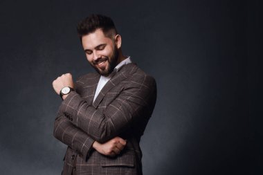 Siyah arka planda şık takım elbiseli yakışıklı sakallı adam. Metin için boşluk