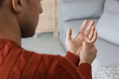 Tetik parmağından muzdarip bir adam, yakın plan.