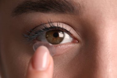 Gözüne kontakt lens takan genç kadının yakın görüntüsü