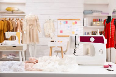 Terzi atölyesindeki kumaşlı modern dikiş makinesi.