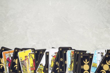 Gri masadaki tarot kartları, üst manzara. Metin için boşluk.