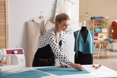 Atölyede terzi kumaşı tebeşirle işaretliyor