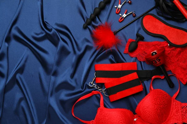 性玩具 饰物和内衣在蓝色丝质面料上 案文的篇幅 — 图库照片