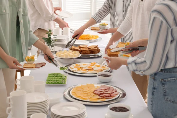 Kahvaltıda yemek yiyen insanlar, yakın çekim. Büfe servisi