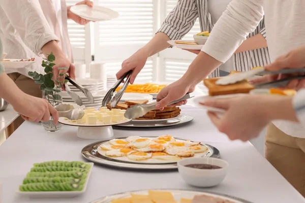 Kahvaltıda yemek yiyen insanlar, yakın çekim. Büfe servisi