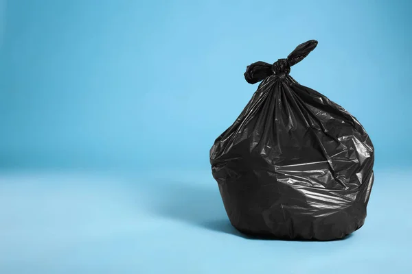 Zwarte Vuilniszak Vol Vuilnis Lichtblauwe Achtergrond Ruimte Voor Tekst — Stockfoto