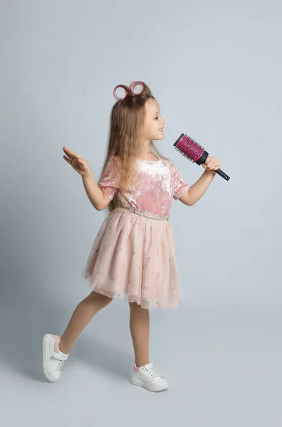 Schattig Klein Meisje Met Haarborstel Zingen Lichtgrijze Achtergrond — Stockfoto