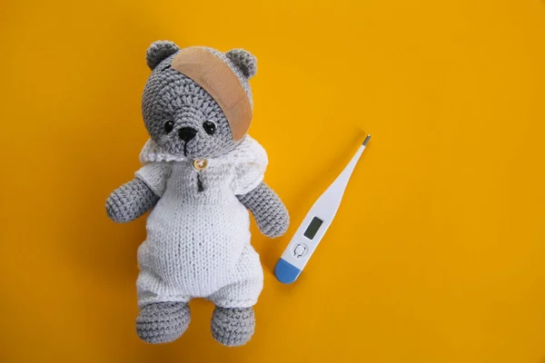 Cute Toy Bear Sticking Plaster Thermometer Orange Background Flat Lay — Stock Photo, Image