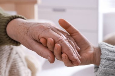 Genç ve yaşlı kadınların el ele tutuşması, yakın çekim.