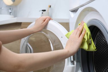 Çamaşır makinesini temizleyen kadın kapalı alanda, yakın plan.