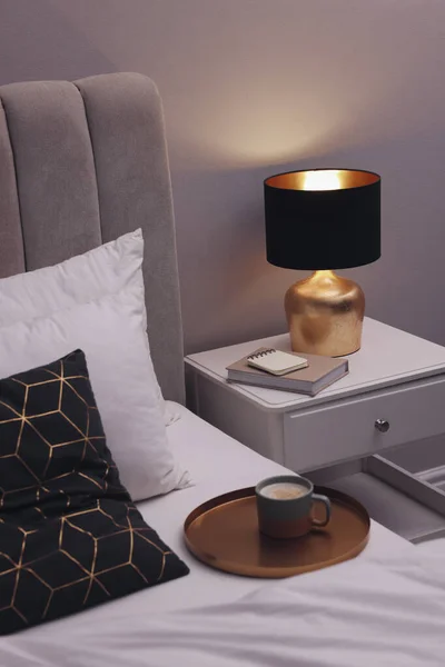 Stilvolle Lampe Und Buch Auf Dem Nachttisch Drinnen Schlafzimmerausstattung — Stockfoto