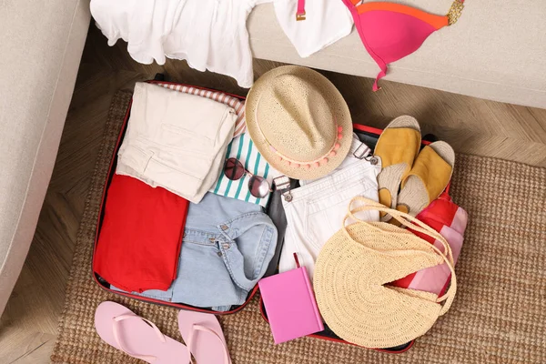 Farklı kadın kıyafetlerinin ve aksesuarların olduğu valizi aç.