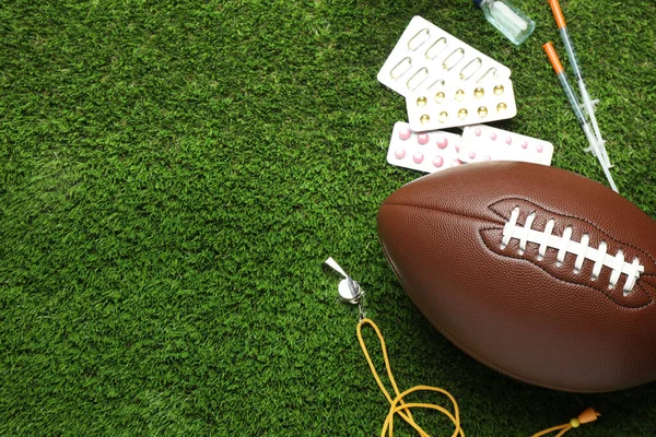 アメリカンフットボールボール 笛や緑の芝生の上でさまざまな薬 テキストのためのスペースを上記のビュー ドーピングの概念 — ストック写真