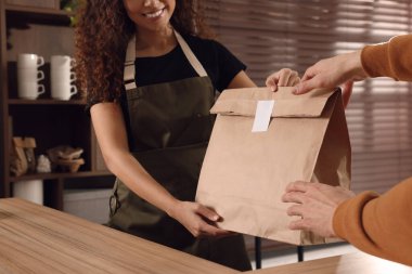 İşçi kafe 'deki müşteriye kese kağıdı veriyor, yakın plan.
