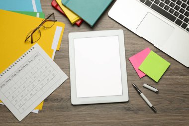 Modern aletler ve ofis malzemeleri ahşap masada, düz yerde. Uzaklık öğrenimi