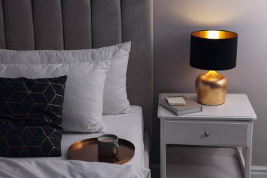 Kaliteli lamba ve kitap komodinin içinde. Yatak odası iç unsuru