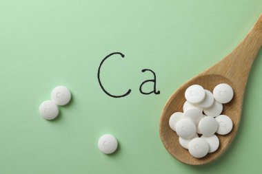 Açık yeşil arka planda kalsiyum takviyeli düz bileşim