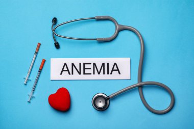 Kelime amnemisi, steteskop, şırıngalar ve açık mavi arka planda dekoratif kalp içeren kart.