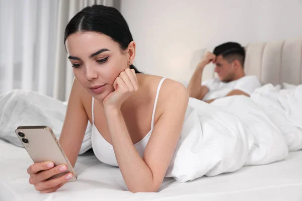 インターネット中毒 女性とともにスマートフォン無視彼女のボーイフレンドでベッドルーム — ストック写真