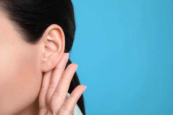 Mujer Mostrando Gesto Mano Oreja Sobre Fondo Azul Claro Primer — Foto de Stock