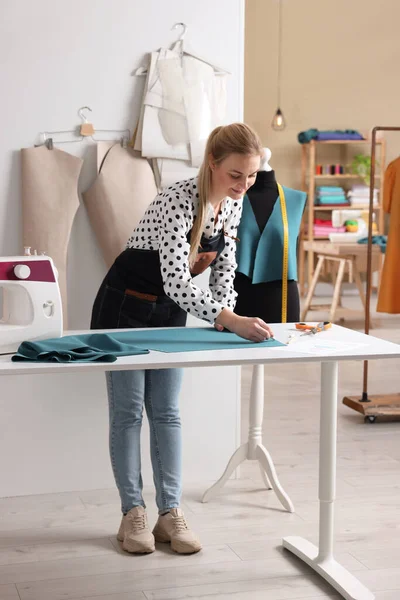 Atölyede terzi kumaşı tebeşirle işaretliyor