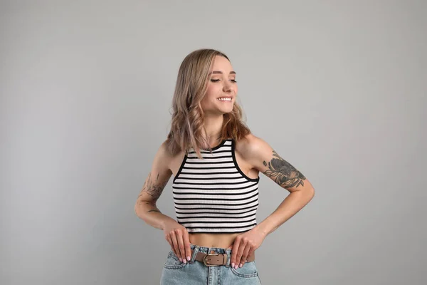 Mooie Vrouw Met Tattoos Armen Tegen Grijze Achtergrond — Stockfoto