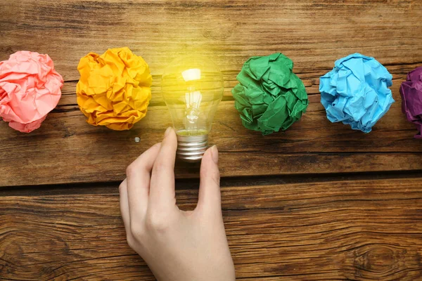 Woman Holding Lightbulb Colorful Paper Balls Wooden Table Top View — ストック写真