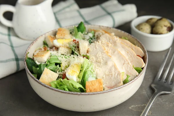 Lezzetli Sezar salatası gri masada, yakın plan.