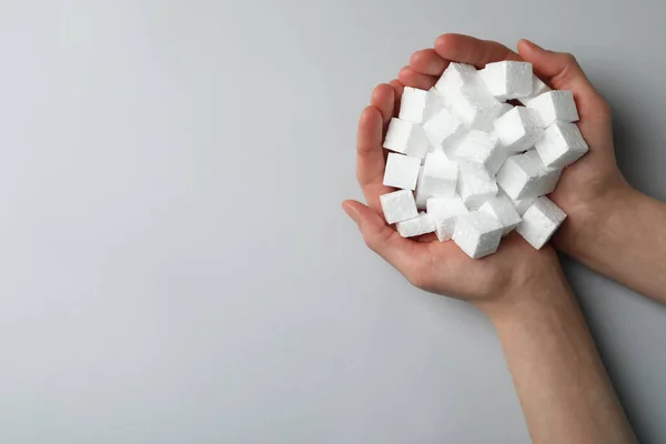 Woman Handful Styrofoam Cubes Light Grey Background Top View Space — стоковое фото