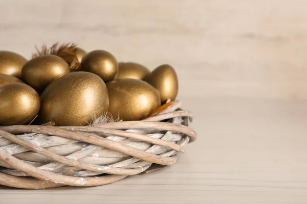 Yuvadaki Altın Yumurtalar Beyaz Ahşap Masada Yakın Plan Metin Için — Stok fotoğraf