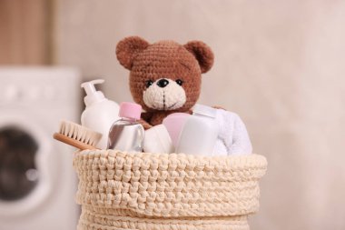 Bebek kozmetik ürünleri, banyo aksesuarları ve oyuncak ayı iç mekânda, yakın plan.