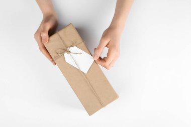 Beyaz arkaplanda etiketli bir pakete sarılı kadın, üst görünüm