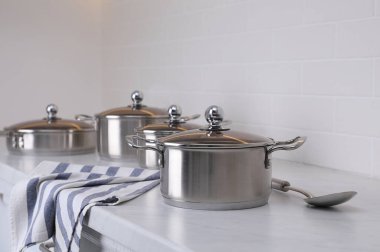 Mutfaktaki tezgahın üstünde yeni temiz yemek takımları ve kaşıklar var.